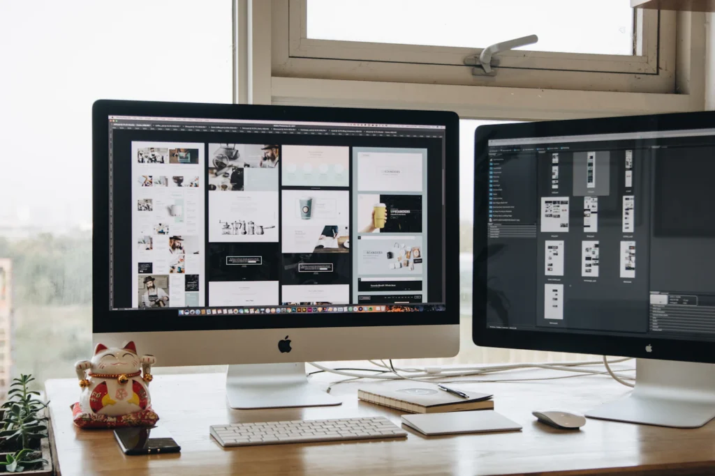 Web design work on two desktop screens